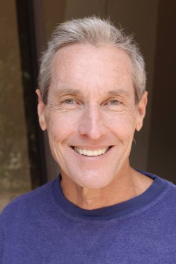 Kameraya bakan mor kazaklı yakışıklı olgun bir adamın yakın plan portresi.