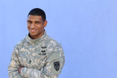 Mavi duvarın önünde üniformalı yakışıklı Afro-Amerikan askerinin yakın plan portresi