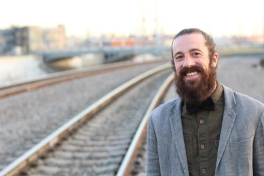 Tarz sahibi sakallı hippi modeli. Erkek saç stili, sokakta yaşam tarzı, tarlanın derinliği.