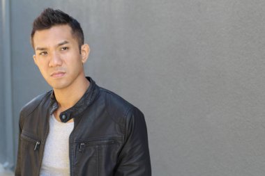 Karışık ırktan yakışıklı genç bir adamın yakın plan portresi. Sokakta günlük kıyafetlerle poz veriyor.