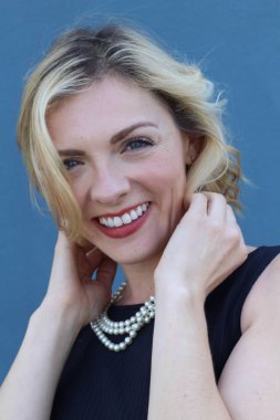 Şık, sarışın, sıradan saç stili ve akşam makyajlı bir kadının güzel portresi. İnci takan kadın