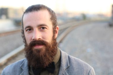 Tarz sahibi sakallı hippi modeli. Erkek saç stili, sokakta yaşam tarzı, tarlanın derinliği.