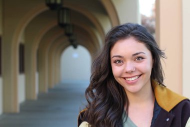 Açık havada duran melez üniversite öğrencisinin portresi.