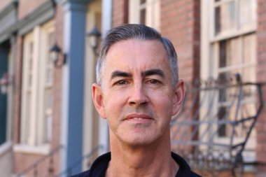 Siyah gömlekli yakışıklı olgun bir adamın yakın plan portresi.