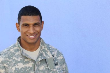 Mavi duvarın önünde üniformalı yakışıklı Afro-Amerikan askerinin yakın plan portresi
