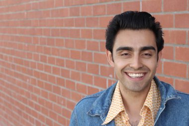 Kırmızı tuğla duvarın arka planında iyi bir adamın yakın plan portresi.