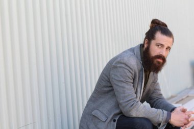 Tarz sahibi sakallı hippi modeli. Erkek saç stili, sokakta yaşam tarzı, tarlanın derinliği.