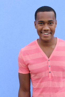 Yakışıklı, Afro-Amerikan, sıradan giyinmiş genç bir adamın yakın plan portresi.