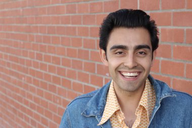 Kırmızı tuğla duvarın arka planında iyi bir adamın yakın plan portresi.