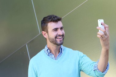 Kareli gömlekli genç bir adamın portresi ve telefonda konuşan Cyan süveteri. 