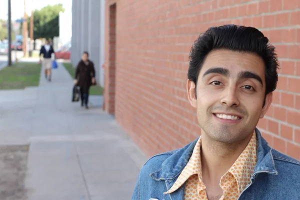 Kırmızı tuğla duvarın arka planında iyi bir adamın yakın plan portresi.