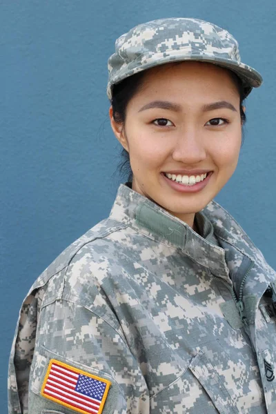 Portrait of serious female army soldier against blue background