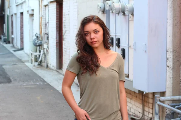 Açık havada duran melez üniversite öğrencisinin portresi.