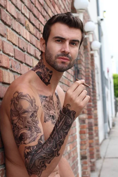 路上でカジュアルな服装でタトゥーのあるハンサムな若い男のクローズアップショット — ストック写真