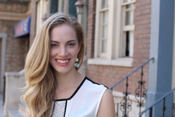 Portrait of naturally beautiful woman in her twenties with blond hair and blue eyes, shot outside in natural sunlight