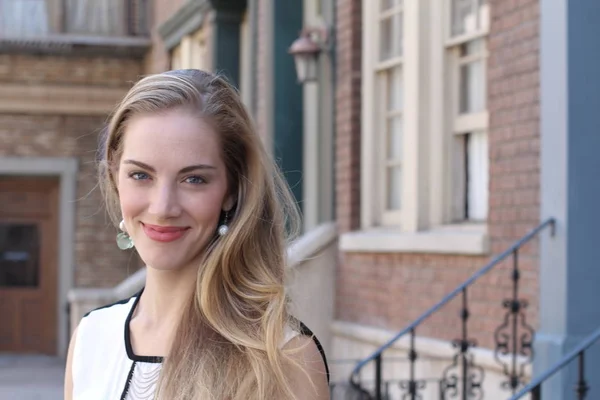 Portrait of naturally beautiful woman in her twenties with blond hair and blue eyes, shot outside in natural sunlight