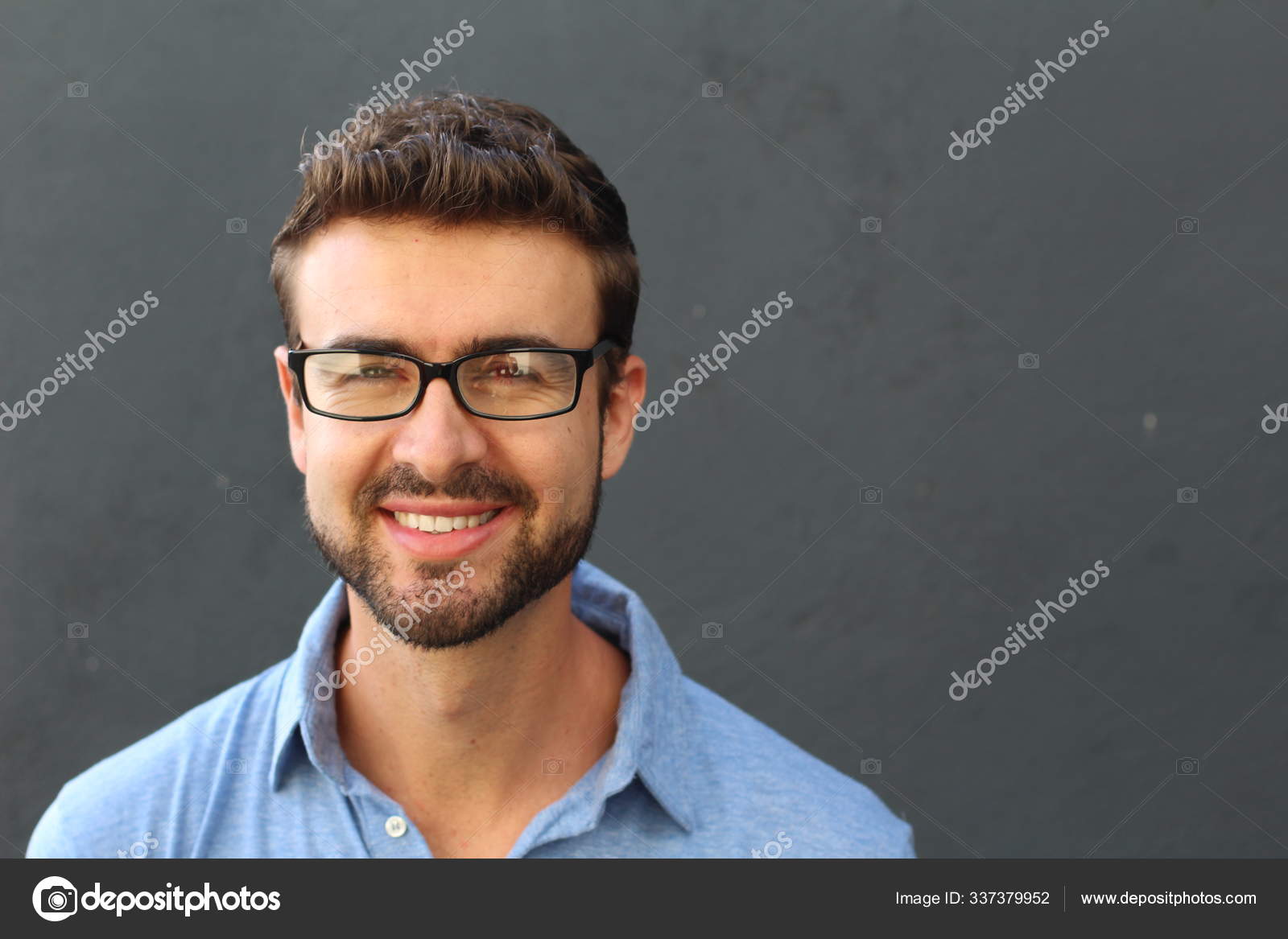 Portret van een leuke man in blauw poloshirt en bril op grijze achtergrond.