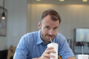 Closeup of handsome man drinking coffee in cafe