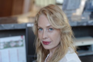 Ofisin içinde oturan güzel sarışın bir kadının portresi. 