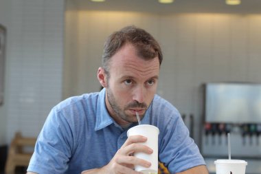 Closeup of handsome man drinking coffee in cafe