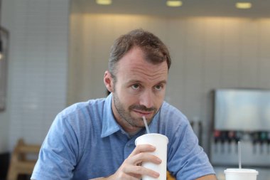 Closeup of handsome man drinking coffee in cafe
