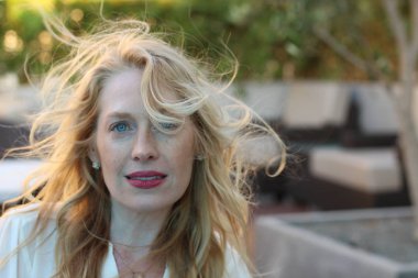 Parkta duran güzel sarışın bir kadının portresi.