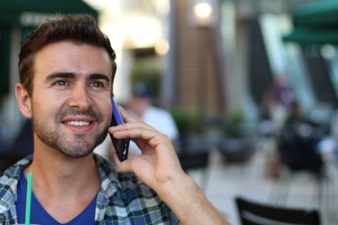 Genç adam şehirde dolaşıyor ve bir telefon görüşmesi yapıyor.