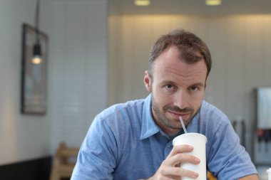 Closeup of handsome man drinking coffee in cafe