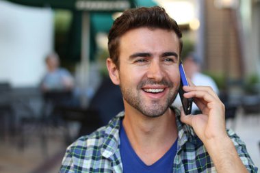 Genç adam şehirde dolaşıyor ve bir telefon görüşmesi yapıyor.