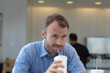 Closeup of handsome man drinking coffee in cafe