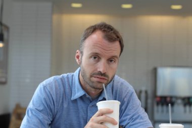 Closeup of handsome man drinking coffee in cafe