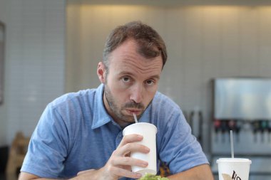Closeup of handsome man drinking coffee in cafe