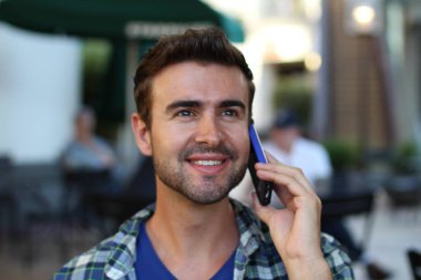 Genç adam şehirde dolaşıyor ve bir telefon görüşmesi yapıyor.