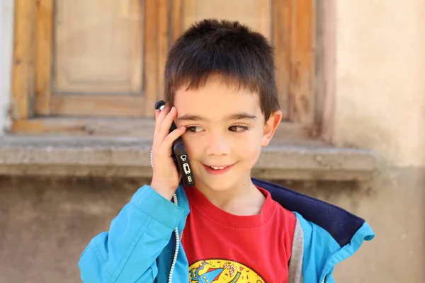 屋外で携帯電話で話すかわいい子供の男の子の肖像画屋外 — ストック写真