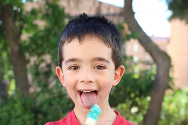 可爱的小男孩白天在公园里吃糖果 — 图库照片
