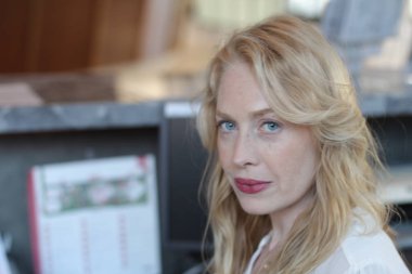 Ofisin içinde oturan güzel sarışın bir kadının portresi. 