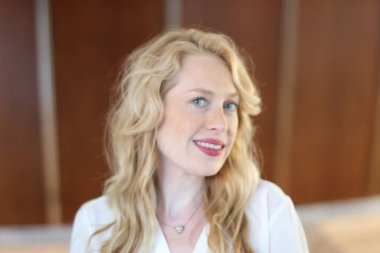 Ofisin içinde oturan güzel sarışın bir kadının portresi. 