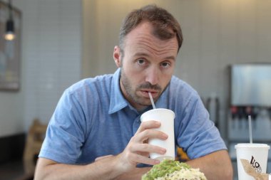 Closeup of handsome man drinking coffee in cafe