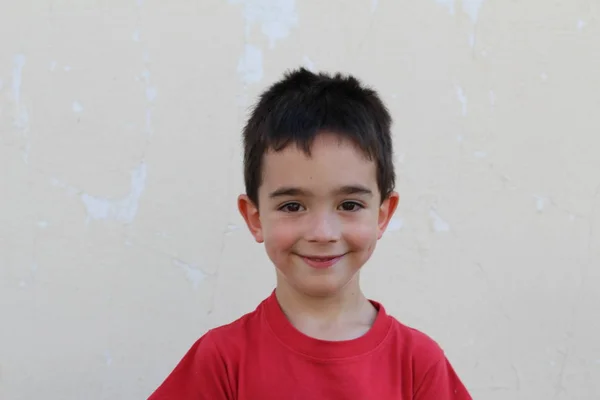 白地に孤立した赤いTシャツの少年のクローズアップ肖像 — ストック写真