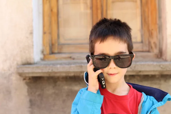 Außenporträt Eines Niedlichen Jungen Mit Großer Sonnenbrille Der Freien Telefoniert — Stockfoto