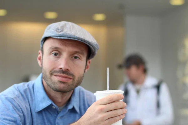 Closeup of handsome man with hipster look drinking coffee in cafe