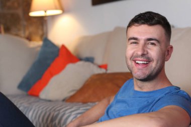 Evde televizyon izleyen rahat bir adam.