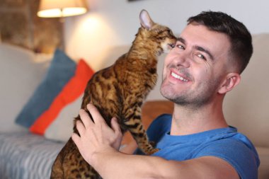 Egzotik kedi yakışıklı sahibiyle oynuyor.