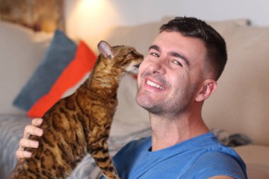 Egzotik kedi yakışıklı sahibiyle oynuyor.