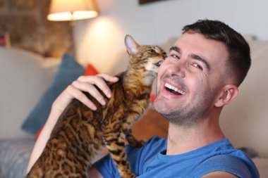 Egzotik kedi yakışıklı sahibiyle oynuyor.