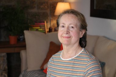 Evdeki güzel olgun kadının yakın plan portresi.