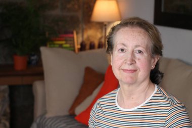 Evdeki güzel olgun kadının yakın plan portresi.