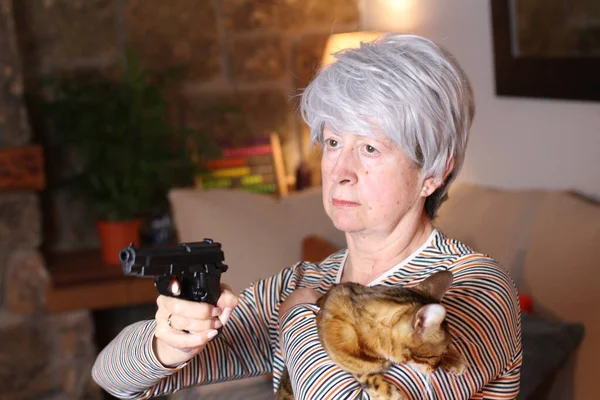 自宅で銃と猫を持っている美しい熟女のクローズアップ肖像 — ストック写真