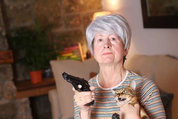 自宅で銃と猫を持っている美しい熟女のクローズアップ肖像 — ストック写真