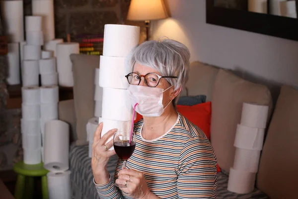 医学マスクとトイレペーパーロールを持つ美しい熟女のクローズアップポートレート自宅で藁で赤ワインを飲む — ストック写真